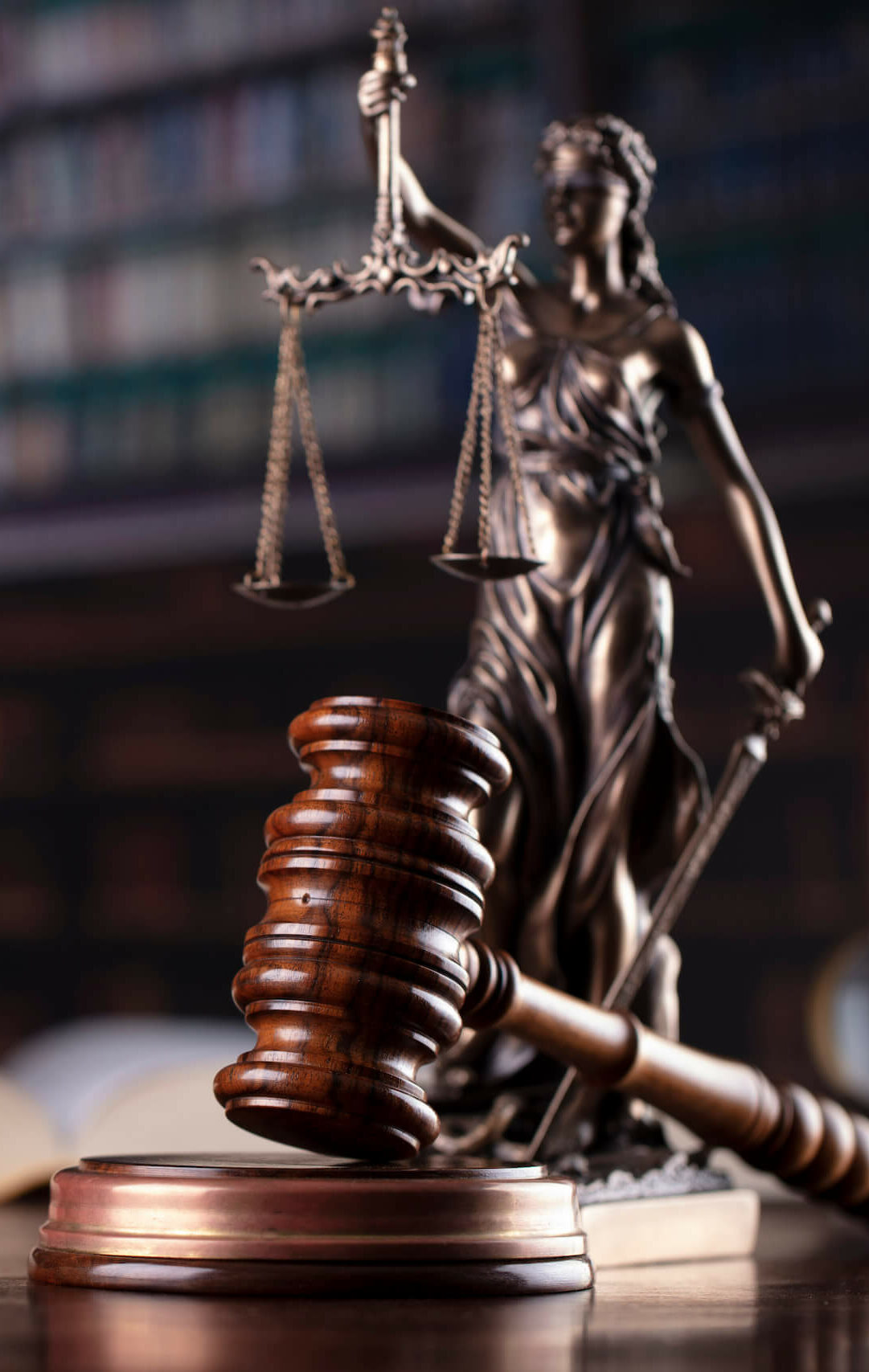 eag_fachgebiete_gesellschaftsrecht Richterhammer mit Gerechtigkeitsstatue im Hintergrund